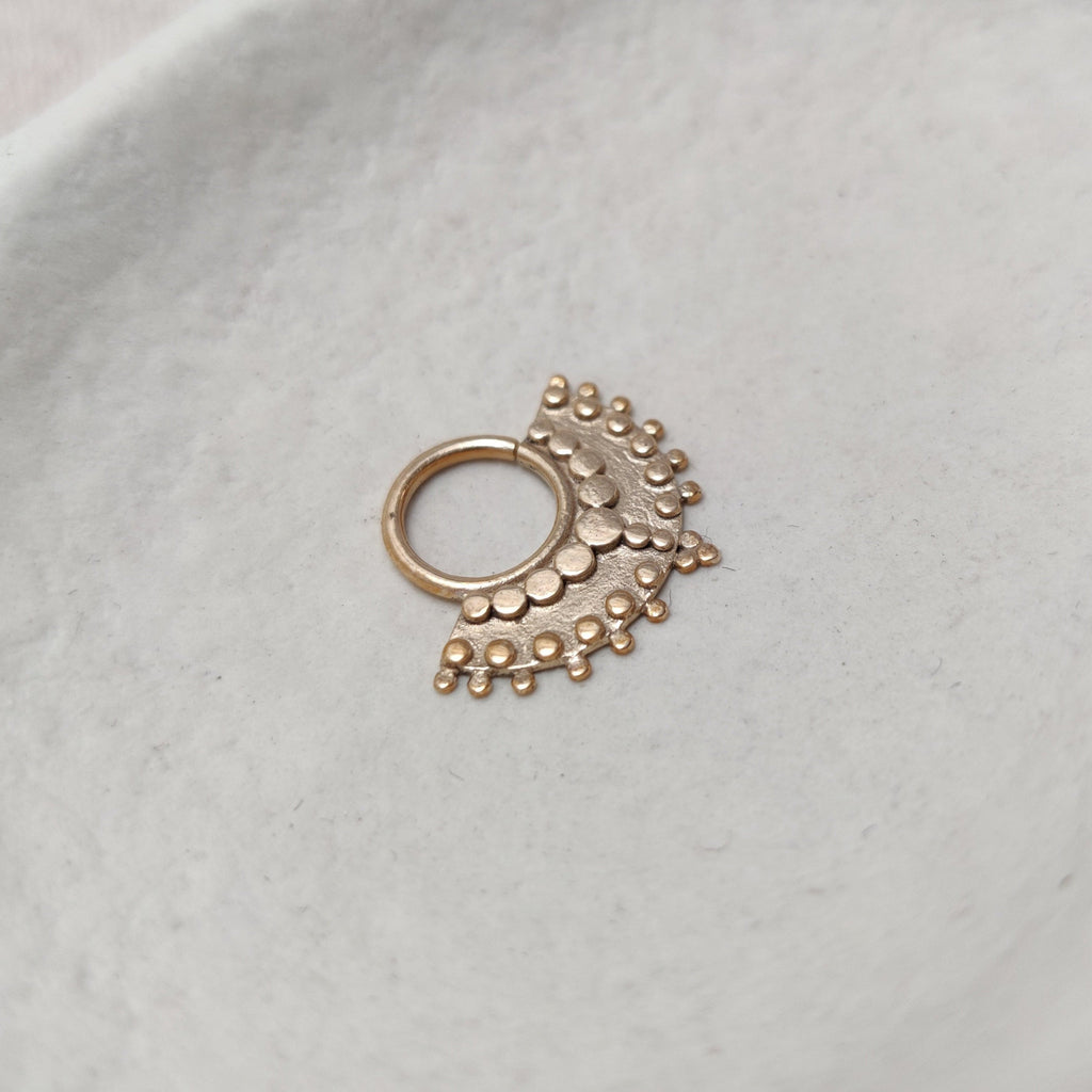 Large gold septum with dotted details, displayed from the left angle.