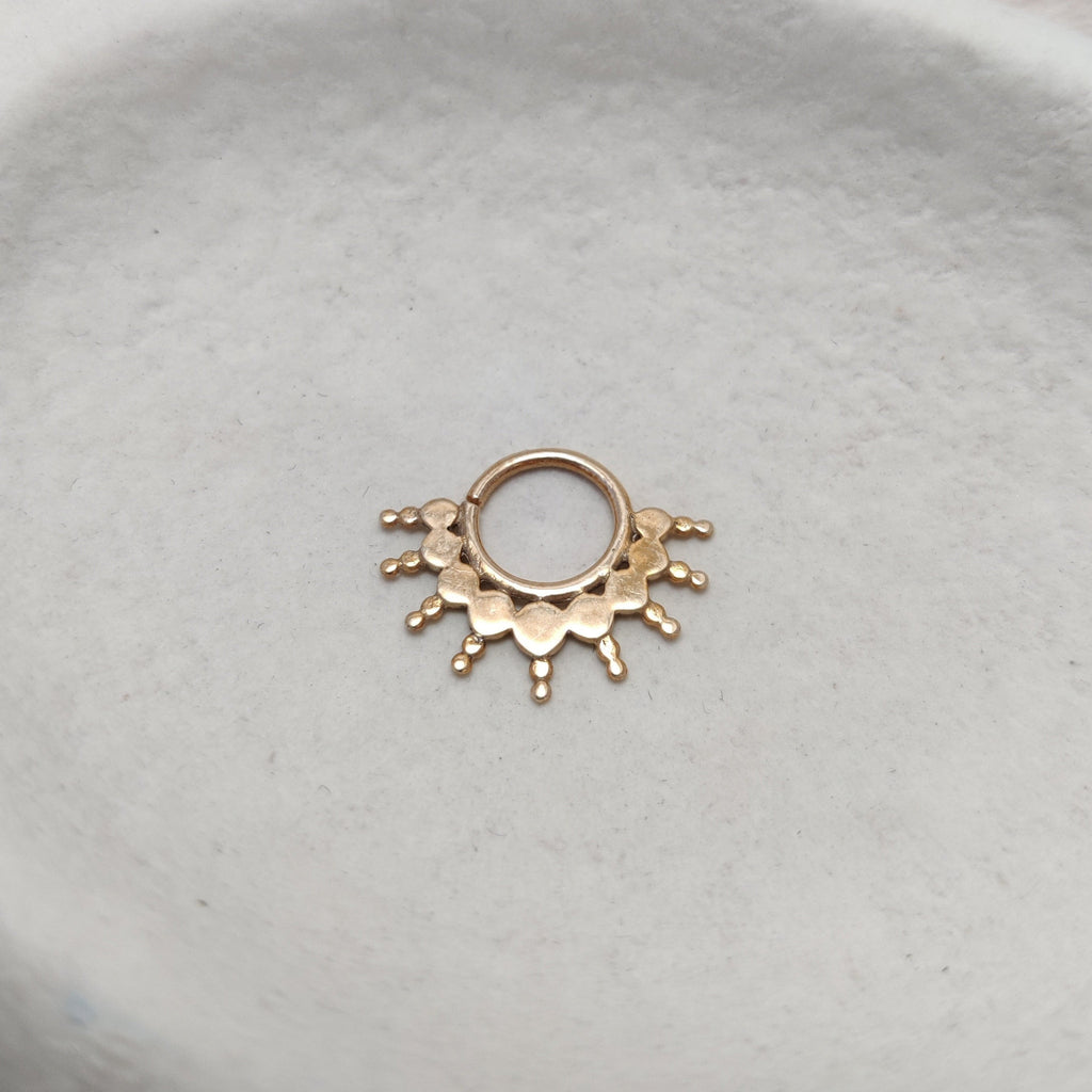 Solid gold septum, displayed on a jewelry plate.