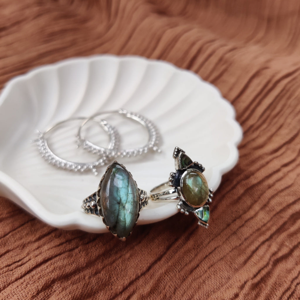 labradorite and sterling silver rings and hoop earrings on jewelry dish, noomaad design