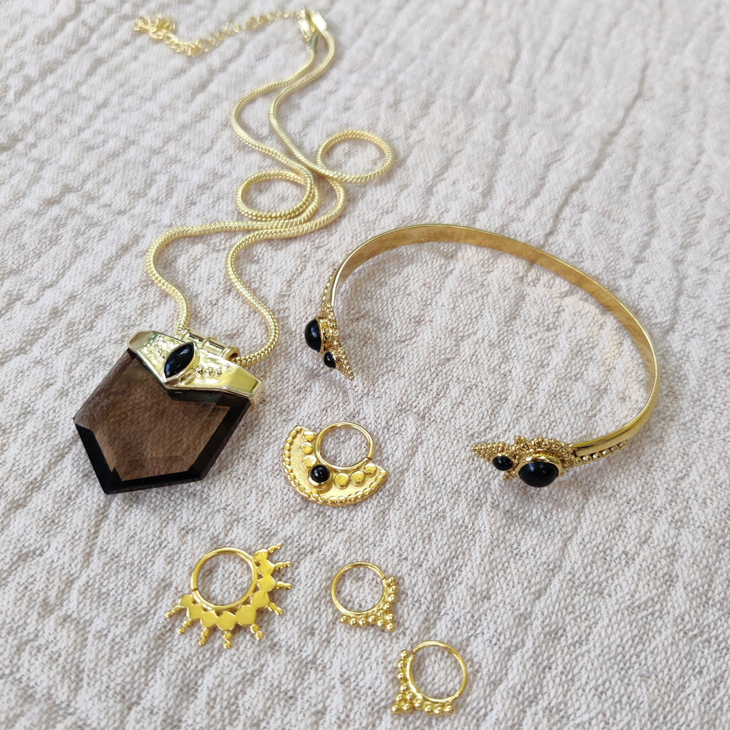 jewelry flatlay with necklace, cuff bracelet and septum jewelry, design by noomaad