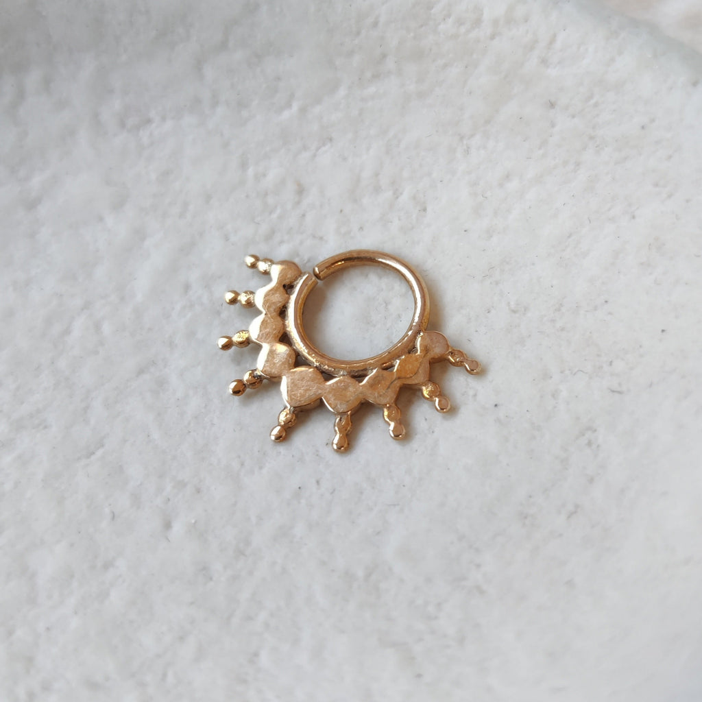 Gold septum nose ring, displayed on white background.