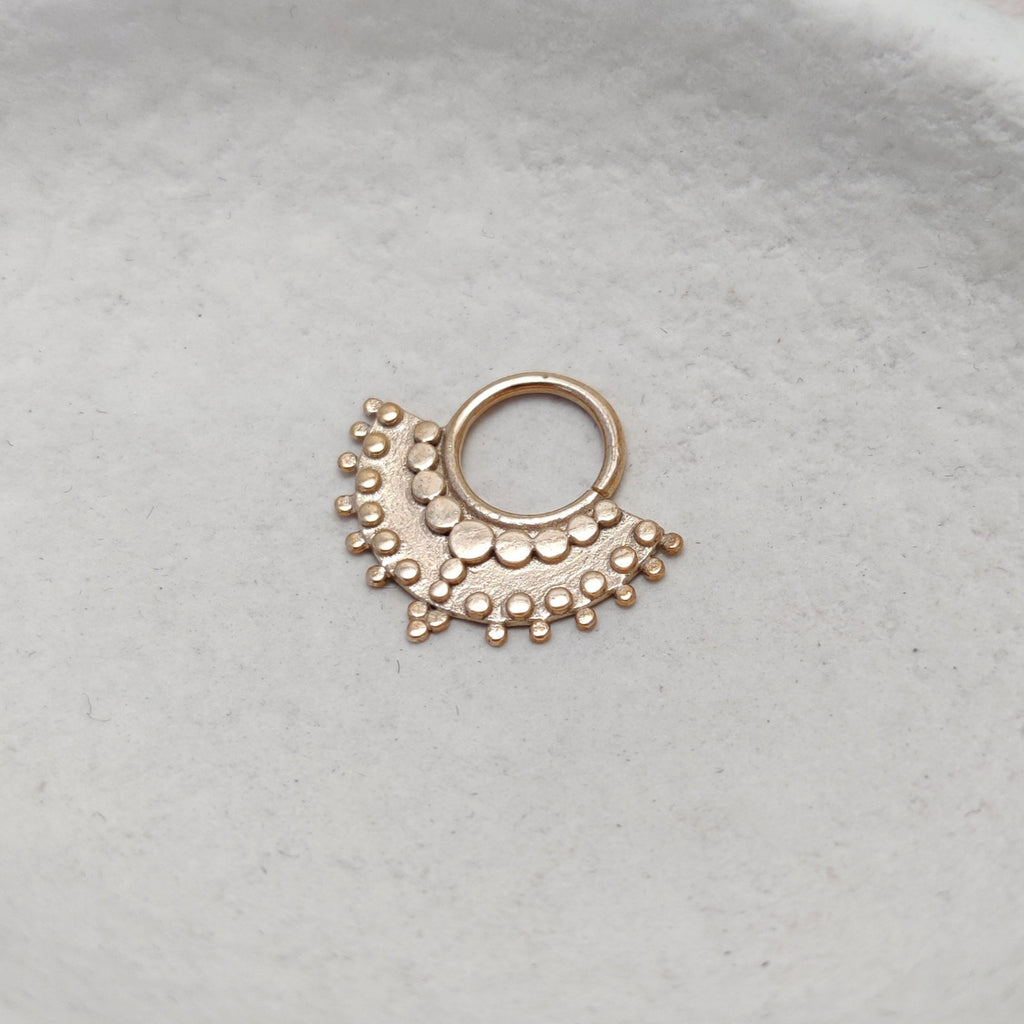 Large gold septum with dotted details, displayed from the right angle.