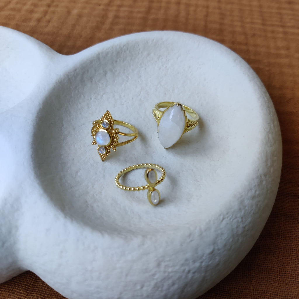 Brass rings with moonstone, displayed on a jewelry plate.