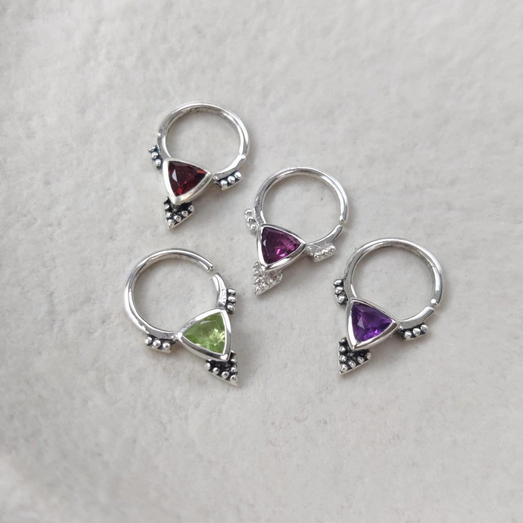 Four pieces of silver septum jewelry with different gemstones, garnet, rhodolite garnet, amethyst and peridot