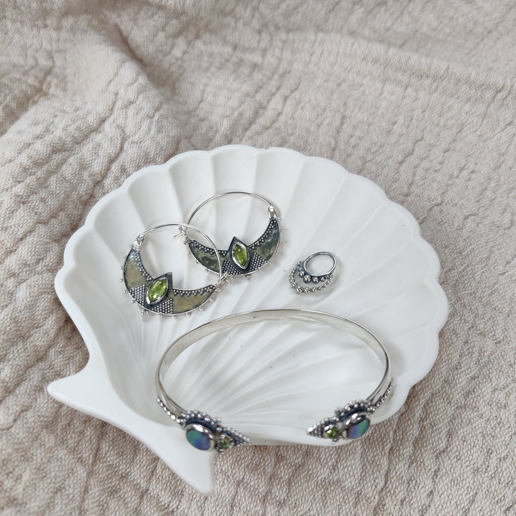 Jewelry dish with silver septum nose ring, peridot earrings and cuff bracelet, design by Noomaad.