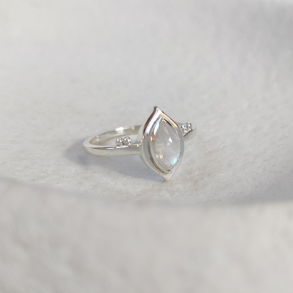 Silver ring with a shimmering moonstone on a white background