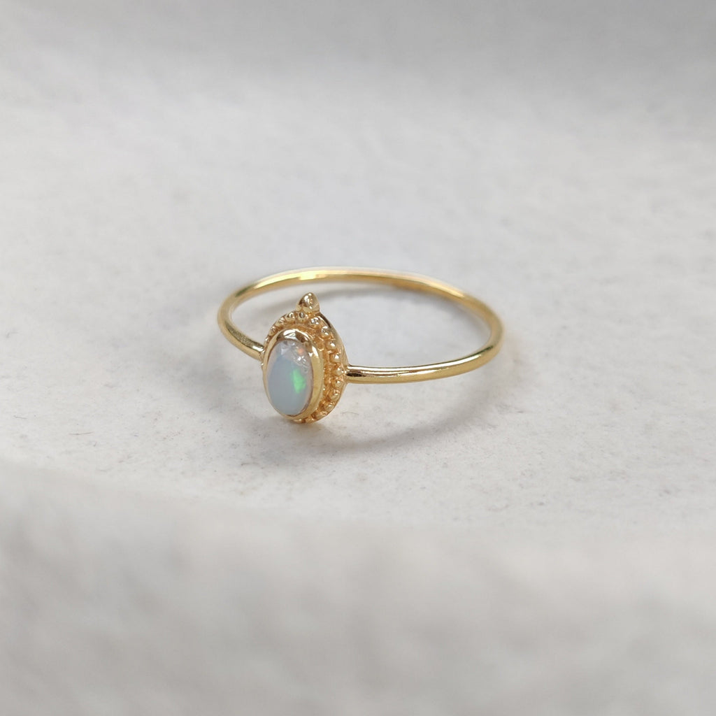 Gold ring with a opal gemstone on a light background