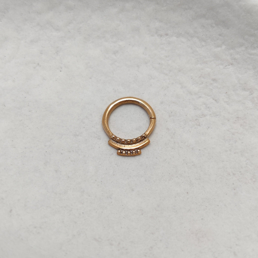 Small solid gold septum, tribal style, 9k gold on plain background.