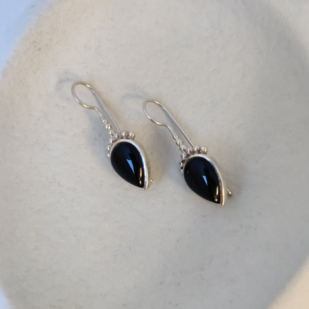 Silver hook earrings with black onyx, highlighting their unique design.