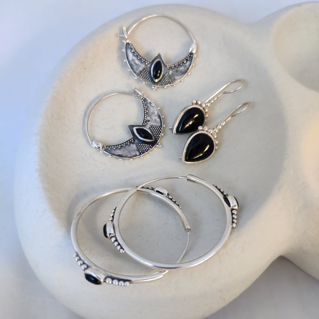 Various silver earrings with black onyx, highlighting their unique design.