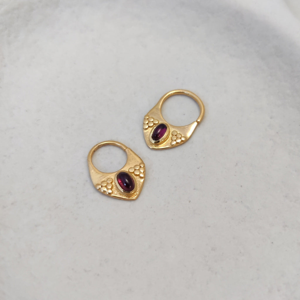 Gold septum jewelry with garnet displayed side by side, comparing the difference between 8mm and 10mm diameters.