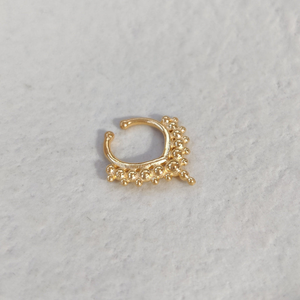 Gold fake septum on a textured white surface.