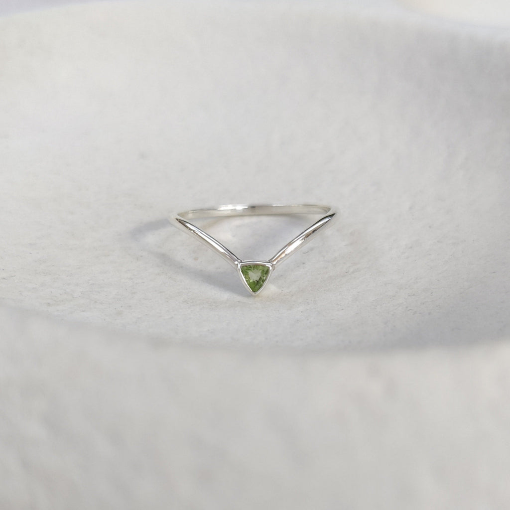 Silver ring with a green gemstone on a white background