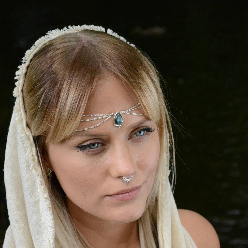 model wearing a bohemian head chain, with drop-shaped labradorite centerpiece, adorned with three cascading chains on each side