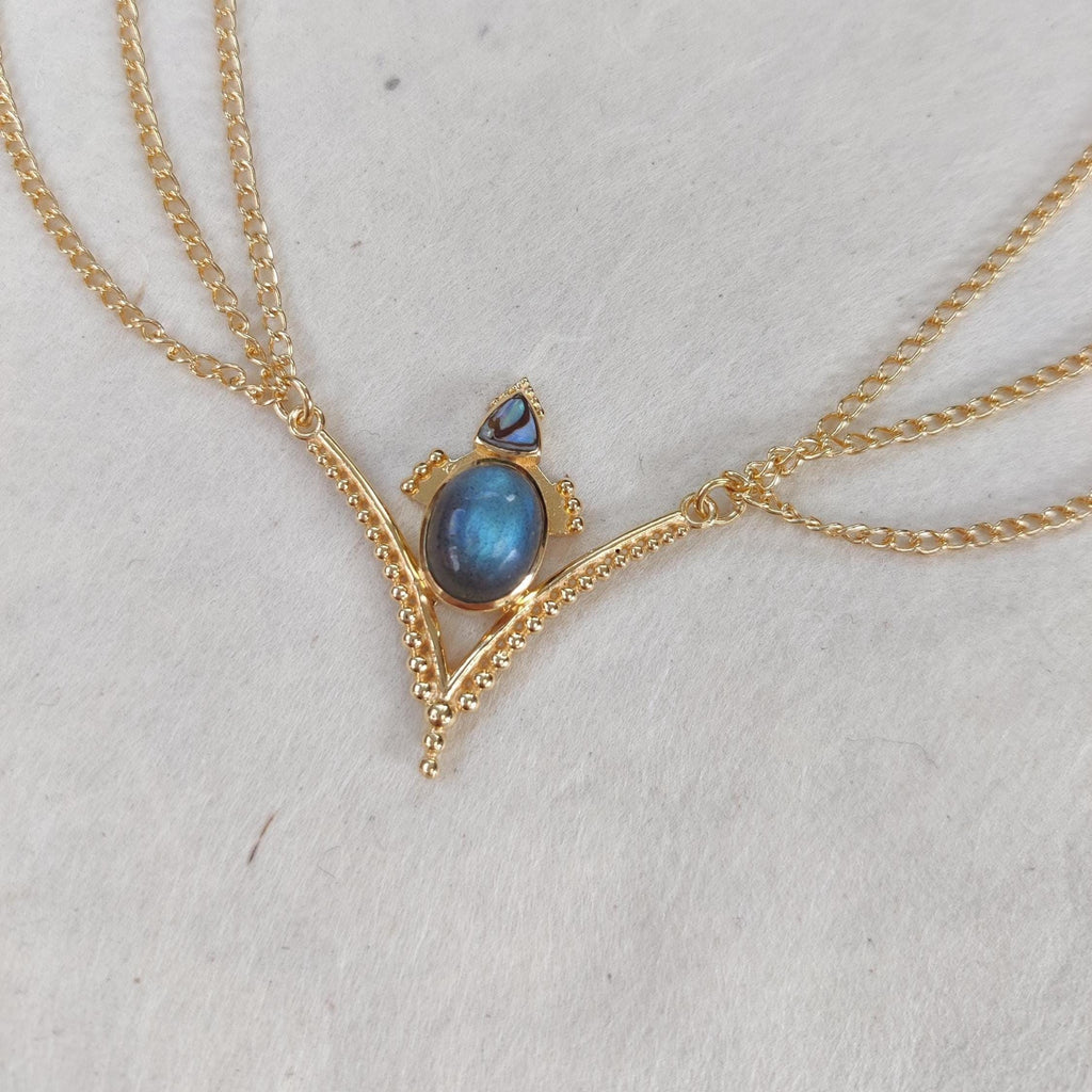 Gold head chain with blue labradorite and abalone shell, the design is v-shaped with three chains draping from the sides.