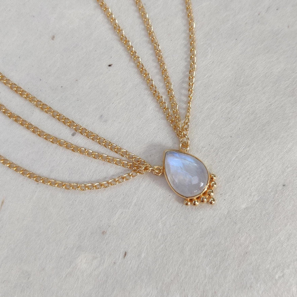 Gold head chain with drop-shaped moonstone centerpiece, and three chains draping on each side.