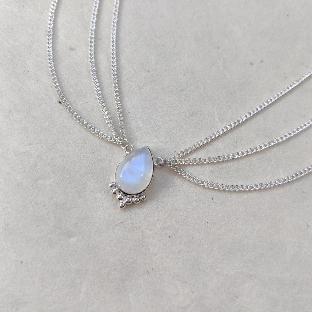 Close-up of a silver head chain with drop-shaped moonstone centerpiece, and three chains draping on each side.