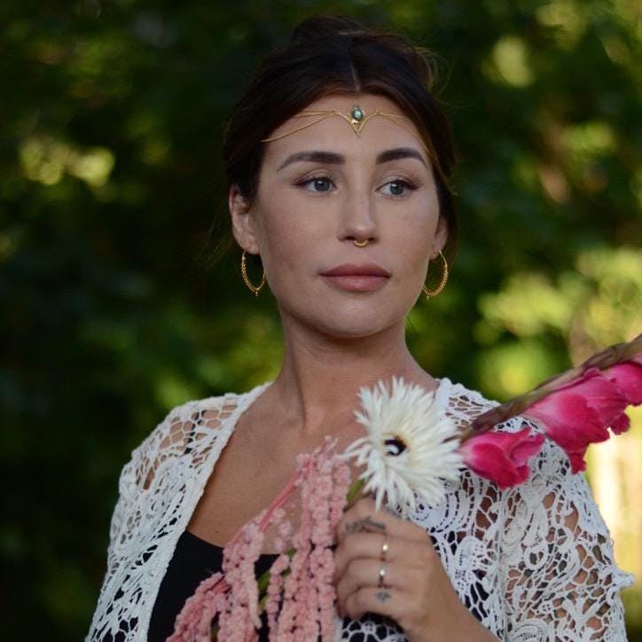 Model wearing a gemstone head chain in gold.