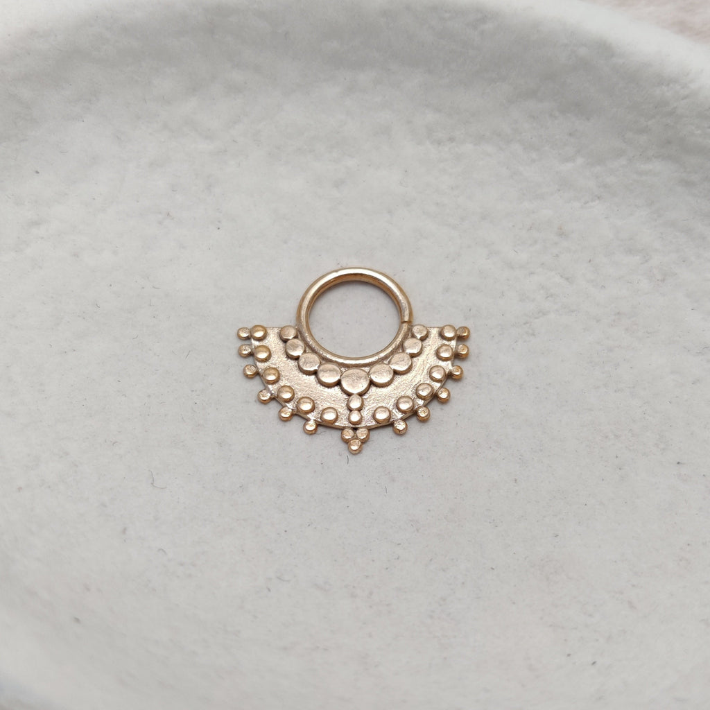 Large tribal septum nose ring crafted from gold.