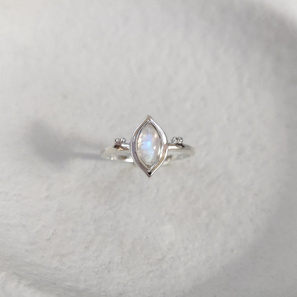 Silver ring with a clear gemstone on a light surface