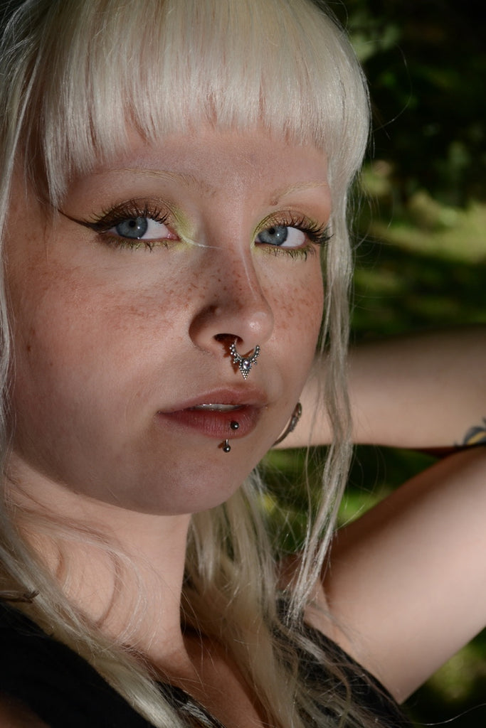 Person with blonde hair and septum piercing with gemstone