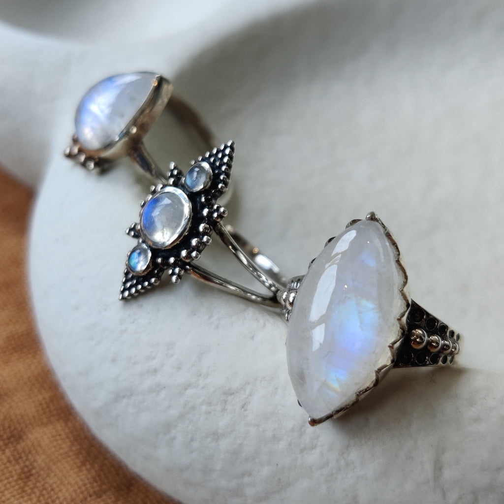 Silver rings with moonstone, displayed on a jewelry plate.