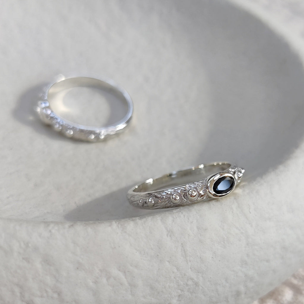 Two textured silver rings on a white surface.