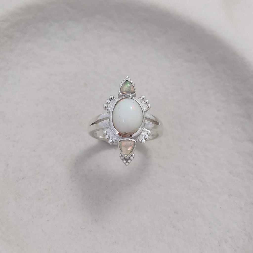 Silver ring with opal gemstones on a white  background