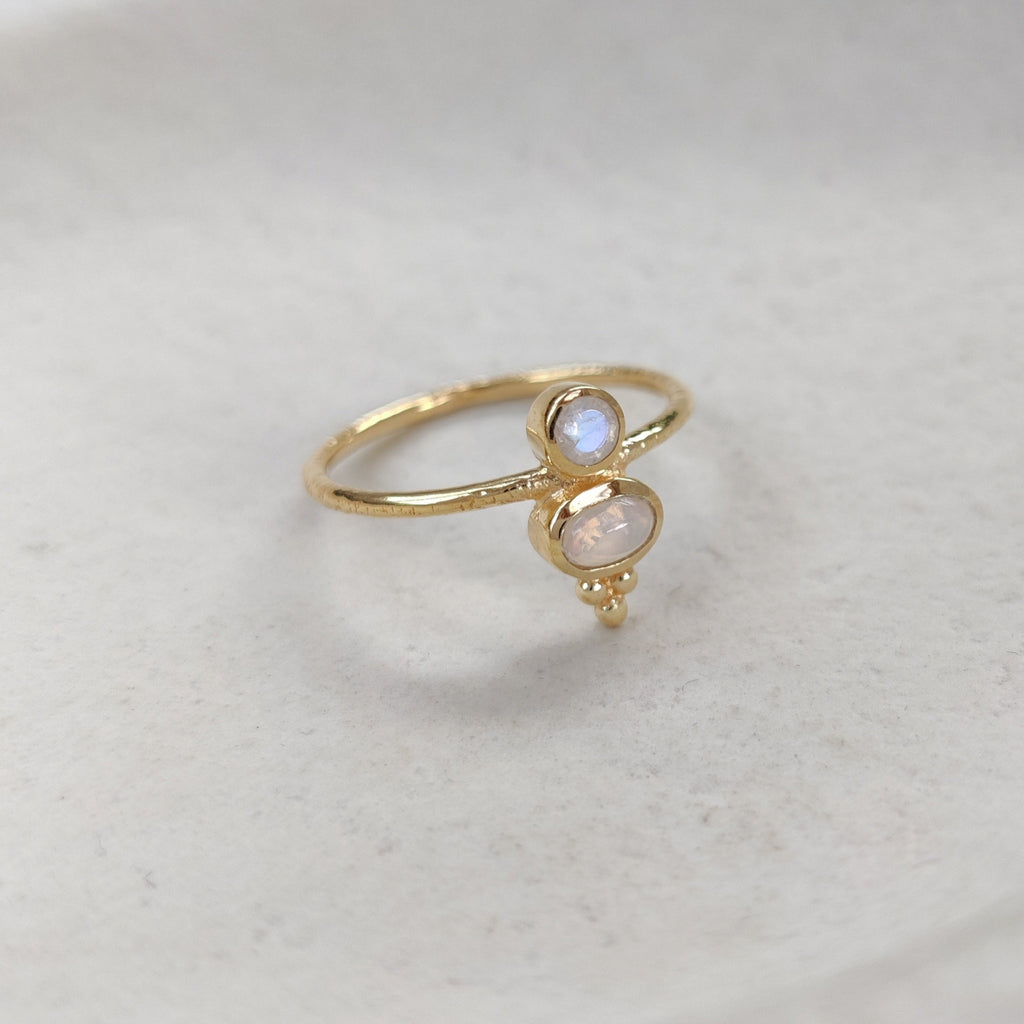 Gold ring with a small gemstone on a white surface