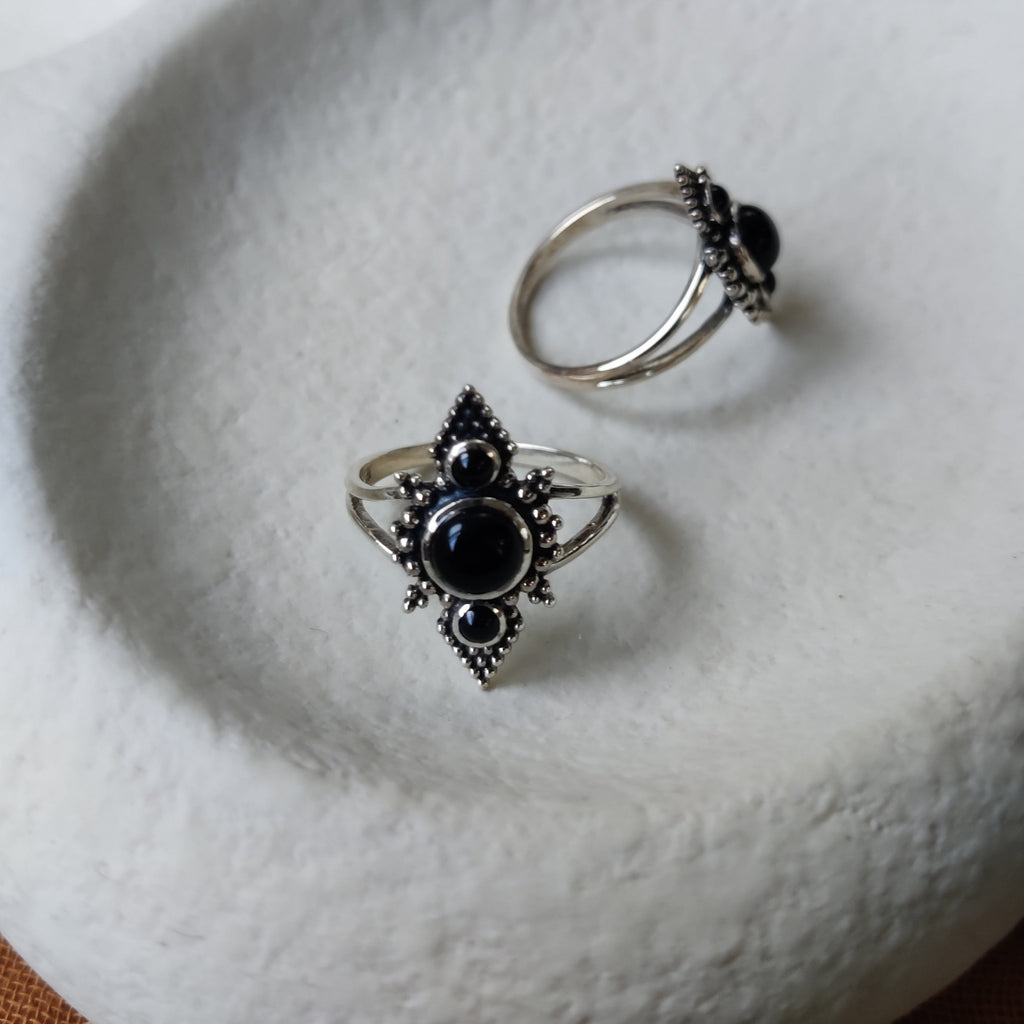 Two silver rings with black onyx gemstones, different angles.