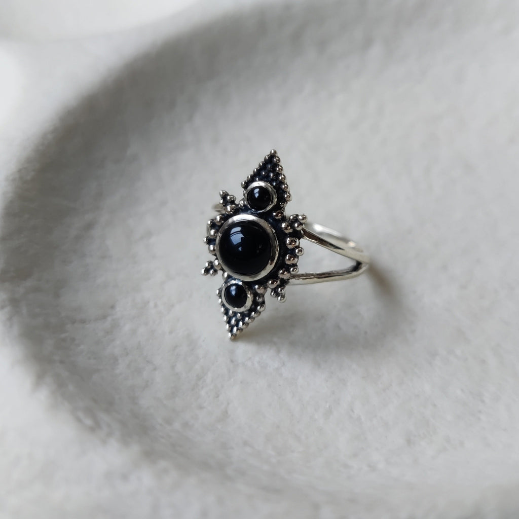 Black onyx silver ring with split band and three gemstones.