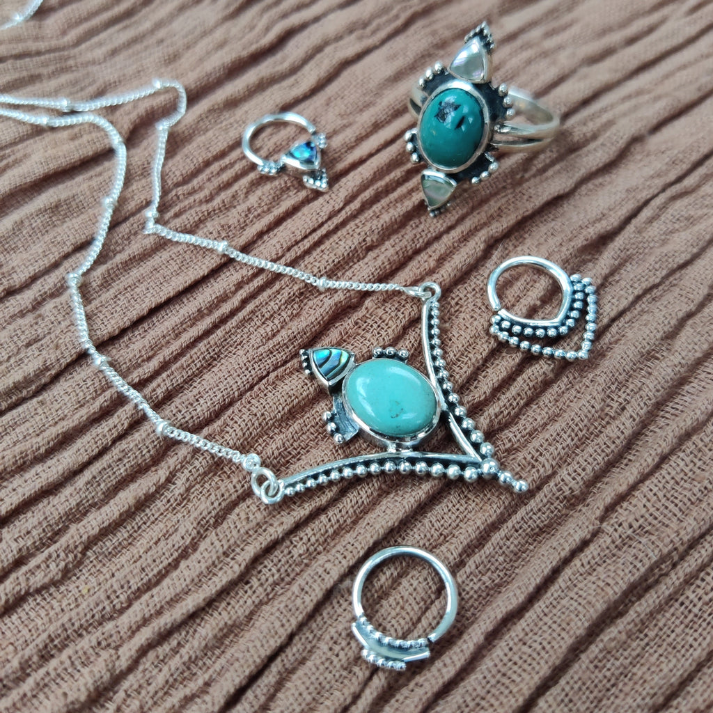 turquoise jewelry flatlay, necklace, ring and septum jewelry 