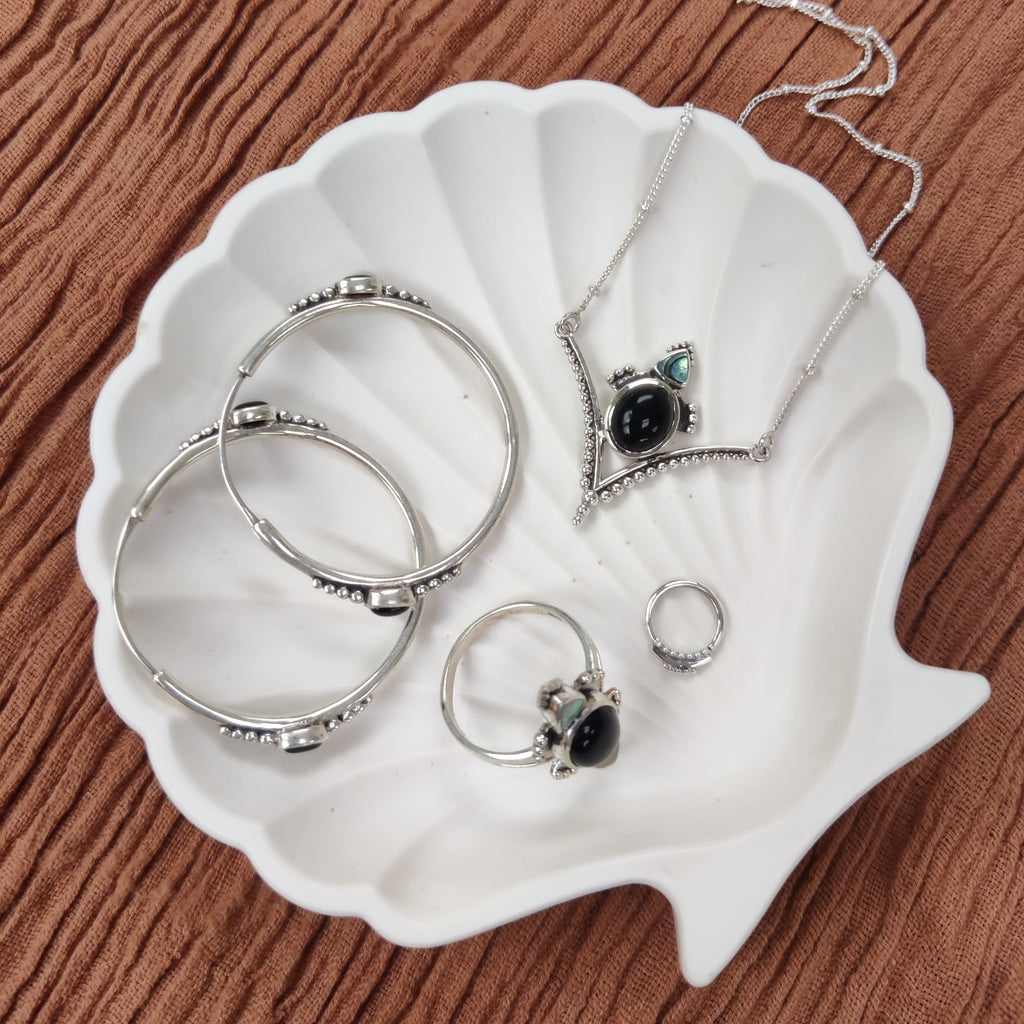 hoop earrings, necklace, ring and septum. sterling silver jewelry on a shell jewelry dish