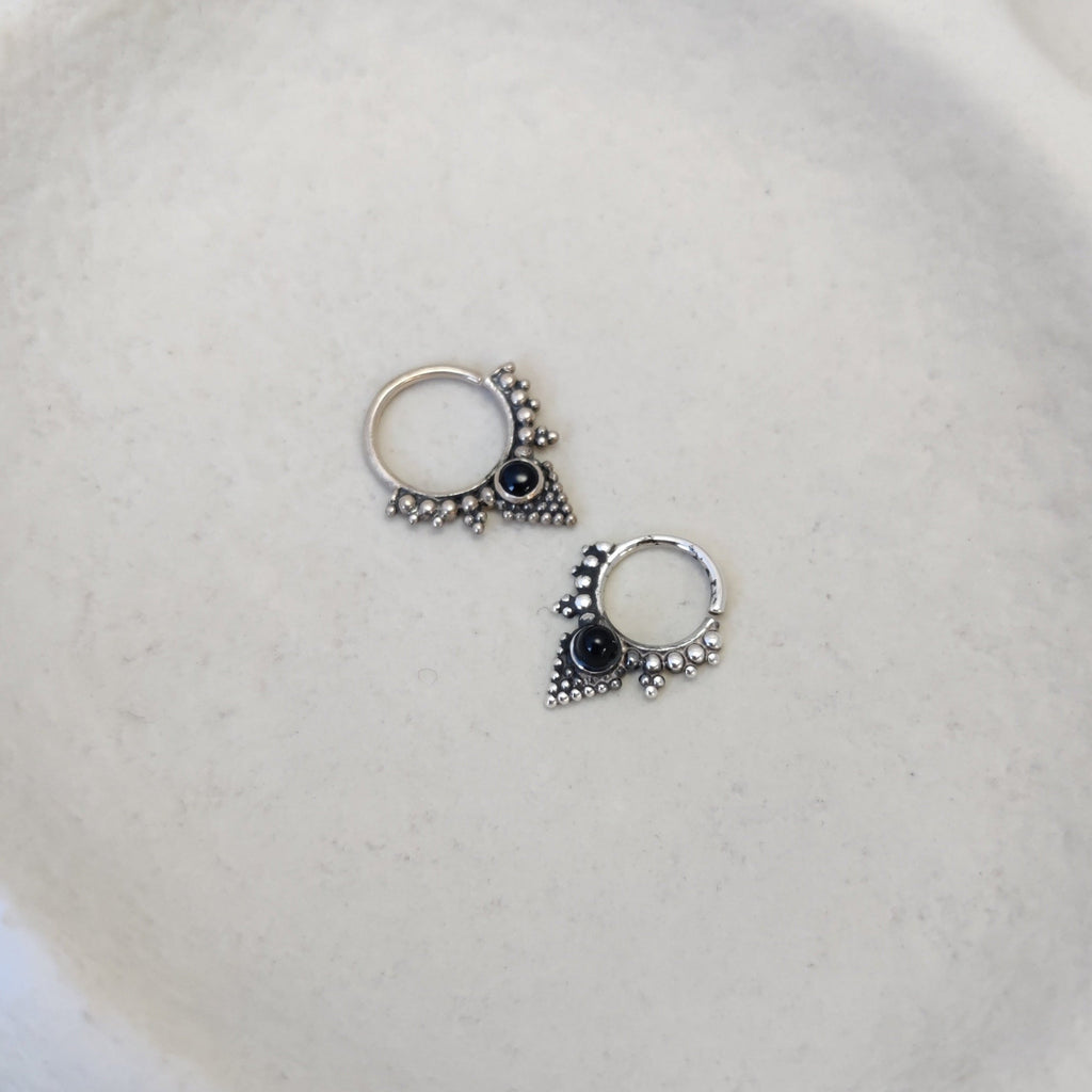 Ornamental silver septum rings with black onyx and intricate dotted details.