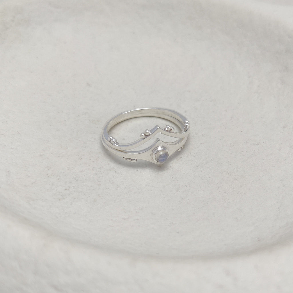 Two silver stacking rings on a white stone surface