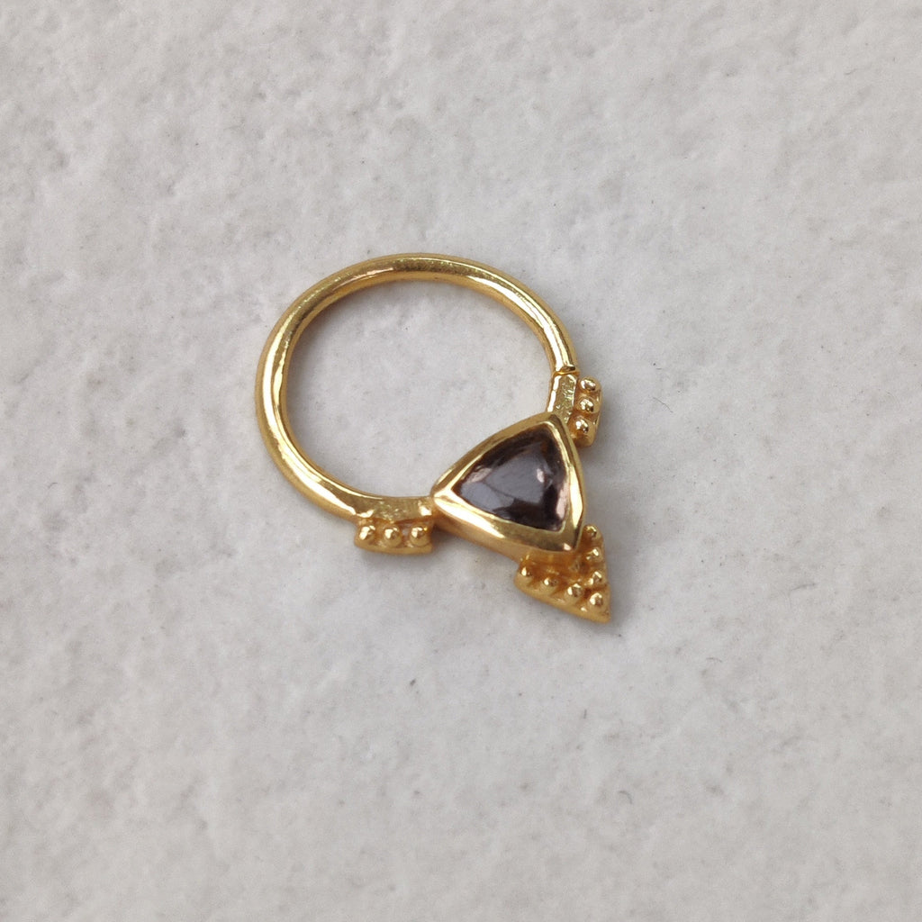 Gold nose ring with a smokey quartz gemstone on a light background