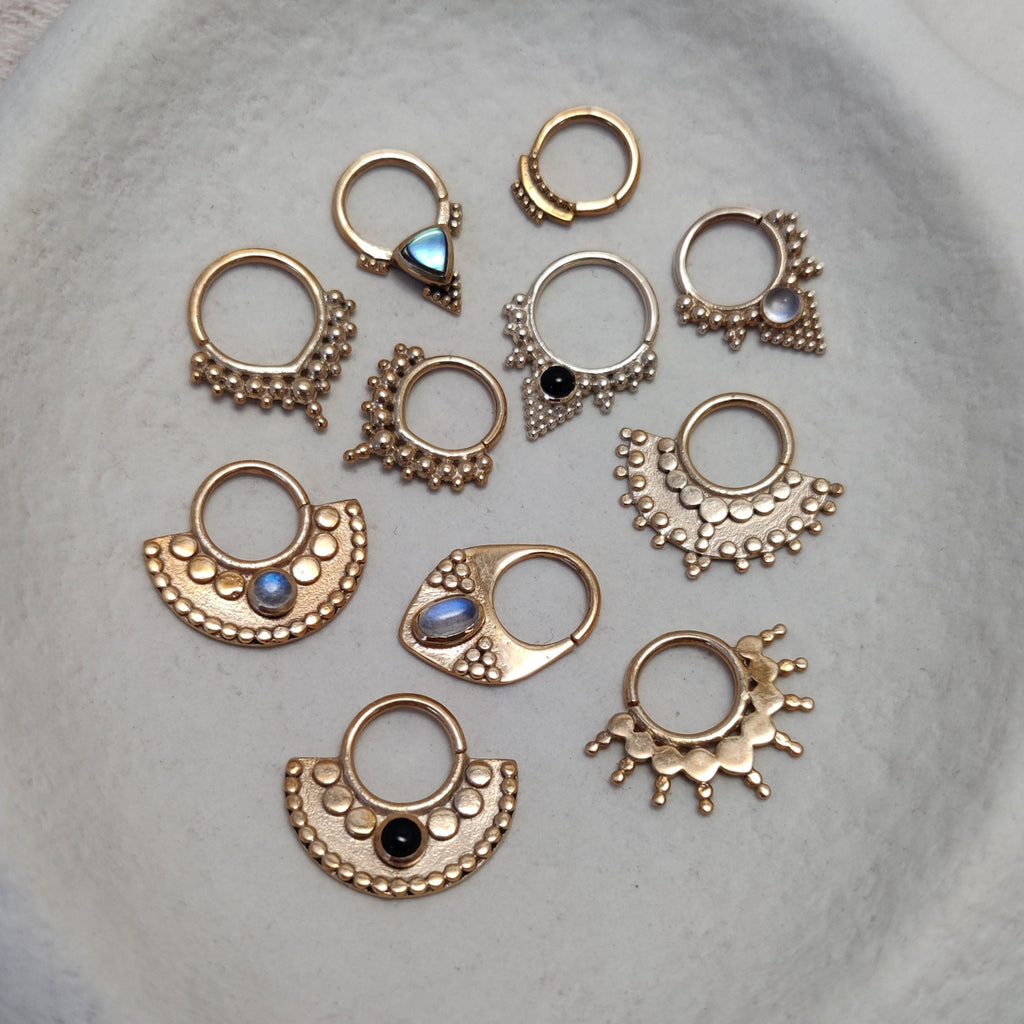 Bohemian and tribal gold septum collection, displayed on jewelry plate. Noomaad design.