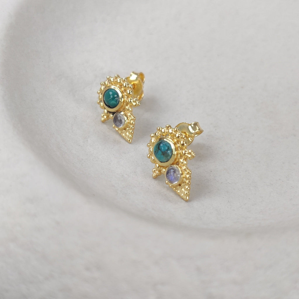 Gold earrings with gemstones on a white background