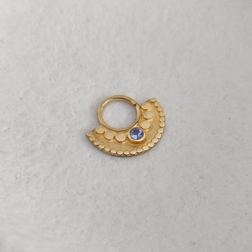 Large gold septum nose ring with tanzanite, adorned with dotted details