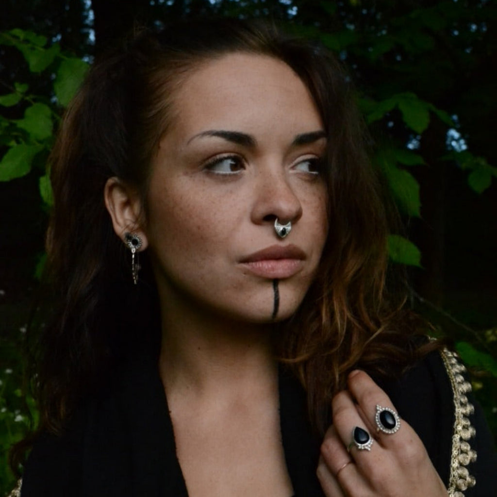 A model wearing a triangle silver septum, captured from the side.