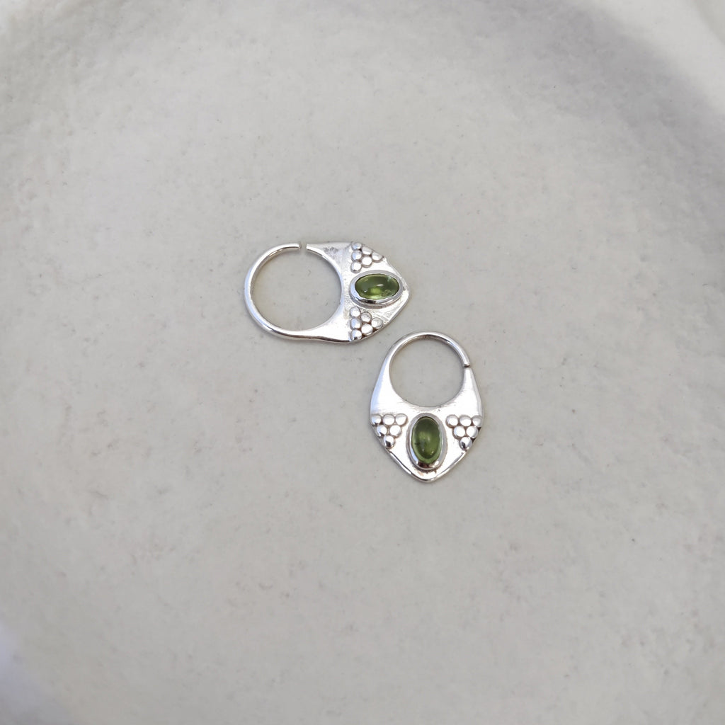 Silver septum rings with peridot, displayed side by side, comparing the difference between 8mm and 10mm diameters and highlighting intricate designs.