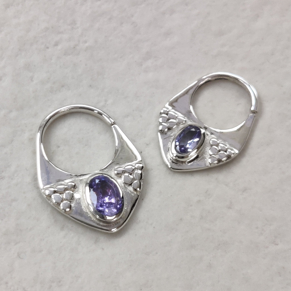 Two triangle shaped septum nose rings in silver with tanzanite, displayed side by side to compare diameter, 10 mm and 8 mm