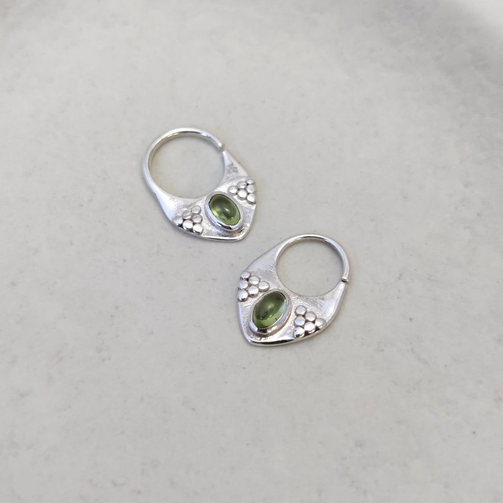 Silver septum jewelry with peridot, displayed side by side, comparing the difference between 8mm and 10mm diameters.