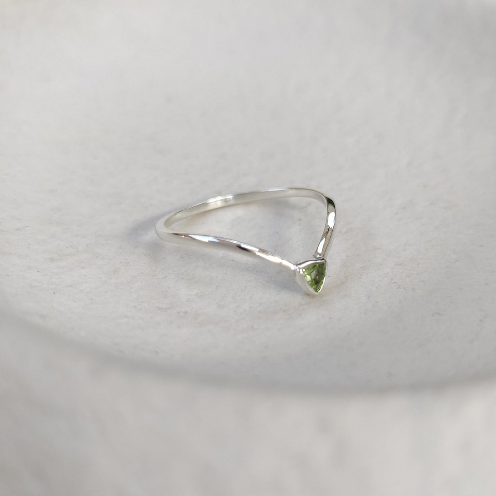 Silver stacking ring with a trillion-shaped green gemstone on a white background.