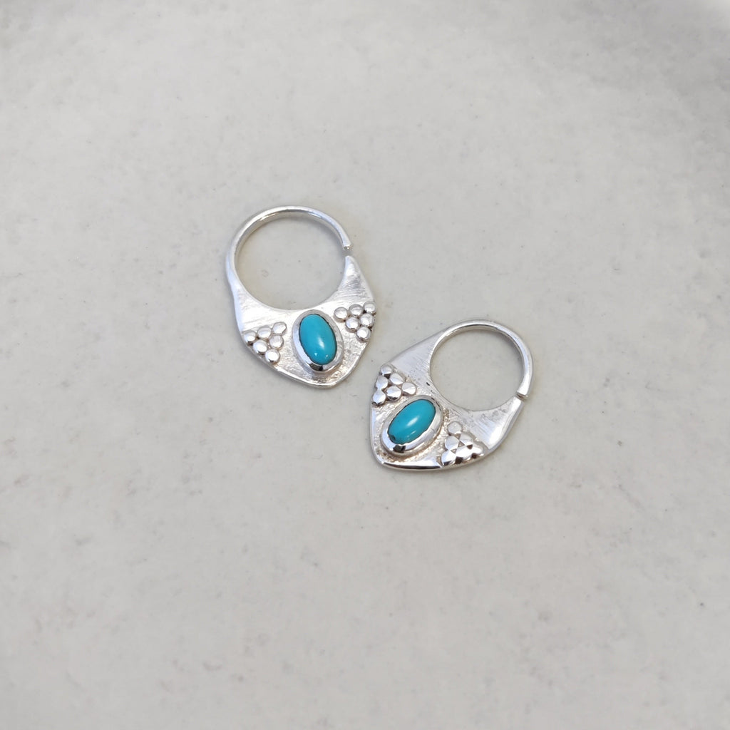 Silver septum rings with turquoise, displayed side by side, comparing the difference between 8mm and 10mm diameters and highlighting intricate designs.