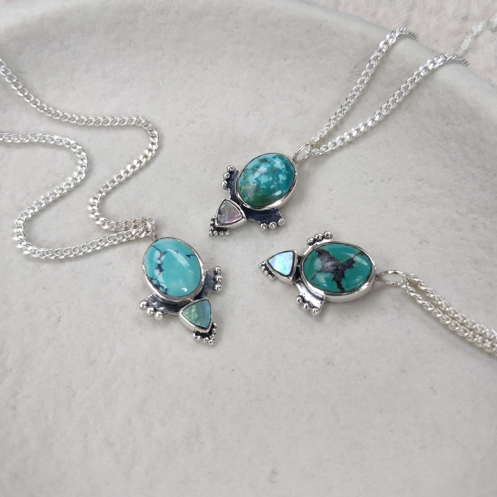 Turquoise gemstone necklaces on a white jewelry plate. Displayed side by side to show the natural differences of tibetan turquoise.