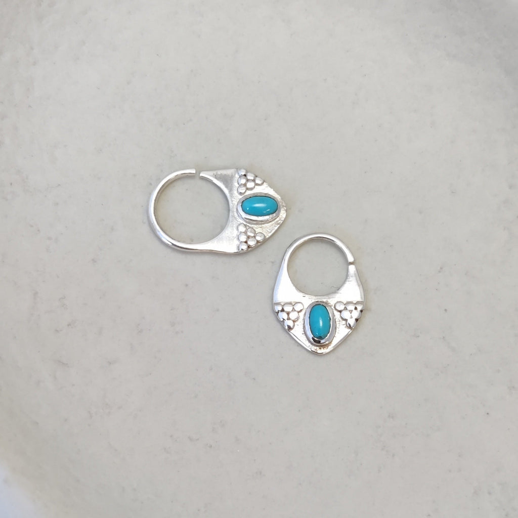 Silver septum rings with turquoise, displayed side by side, comparing the difference between 8mm and 10mm diameters and highlighting intricate designs.