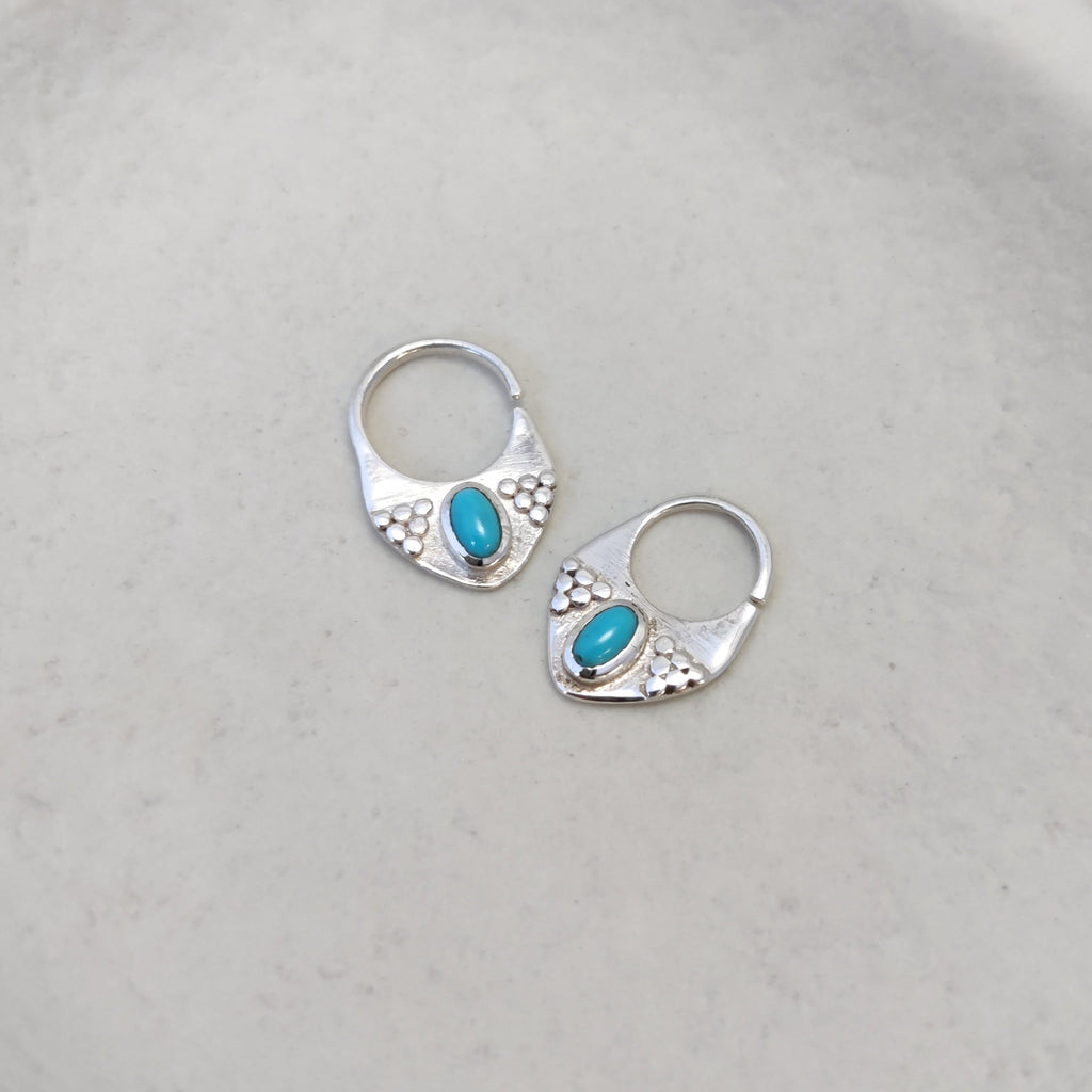 Silver septum jewelry with turquoise, displayed side by side, showcasing the design from different angles.