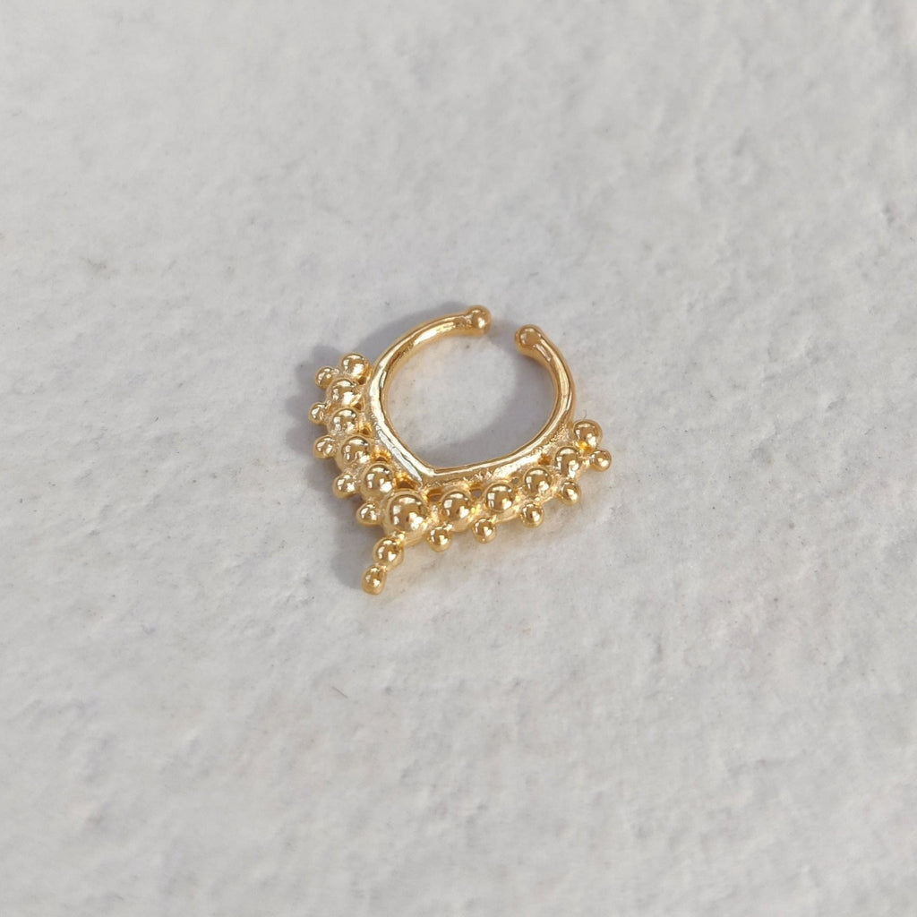 Gold fake septum on a light textured surface.