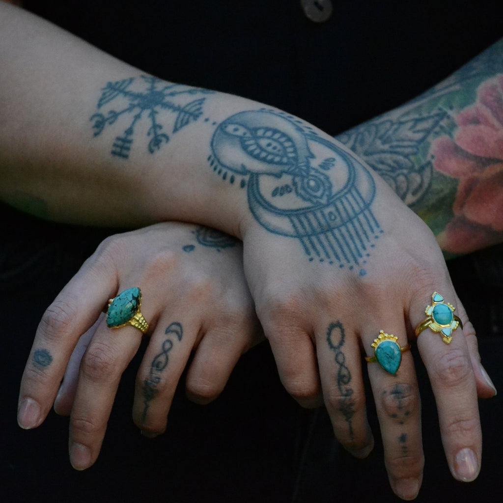 Brass rings with turquoise, worn on a hands.